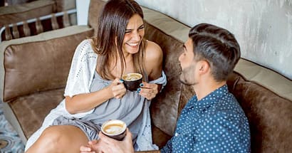 2-5-2 guy and girl sitting on a couch talking on a first date as part of first date etiquette