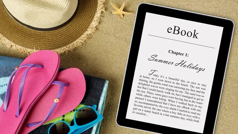 beach picture of pink and purple flip flips, sunglasses, sunhat, and an ebook on a tablet