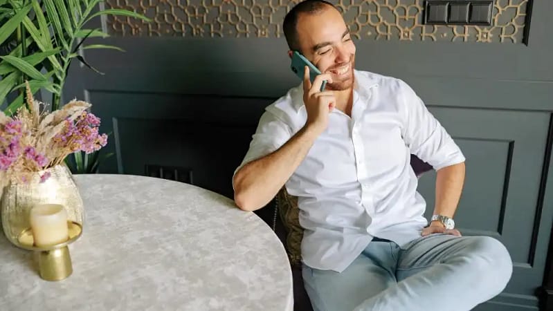 man sitting down at a fancy restaurant talking on the phone