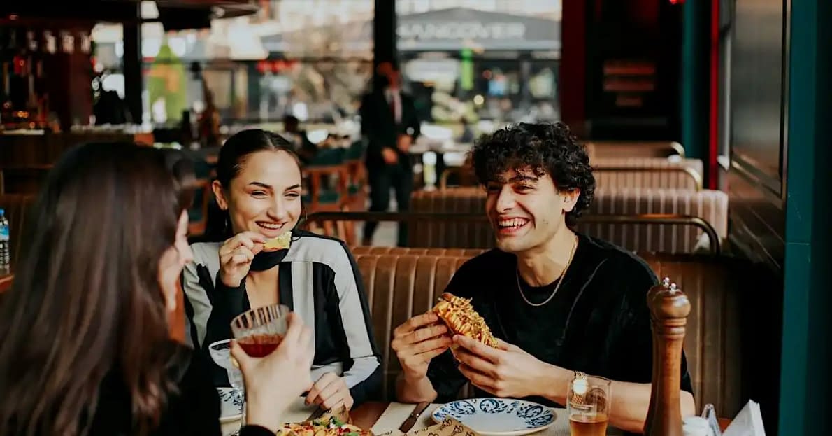 a group of friends at a casual restaurant enjoying a happy day filled with smiles and laughter that like to eat good food