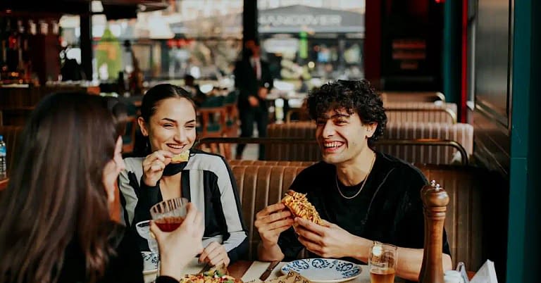 a group of friends at a casual restaurant enjoying a happy day filled with smiles and laughter that like to eat good food