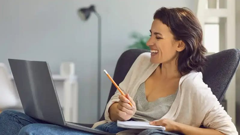woman creating recurring revenue with her website/blog by writing down ideas in a notebook